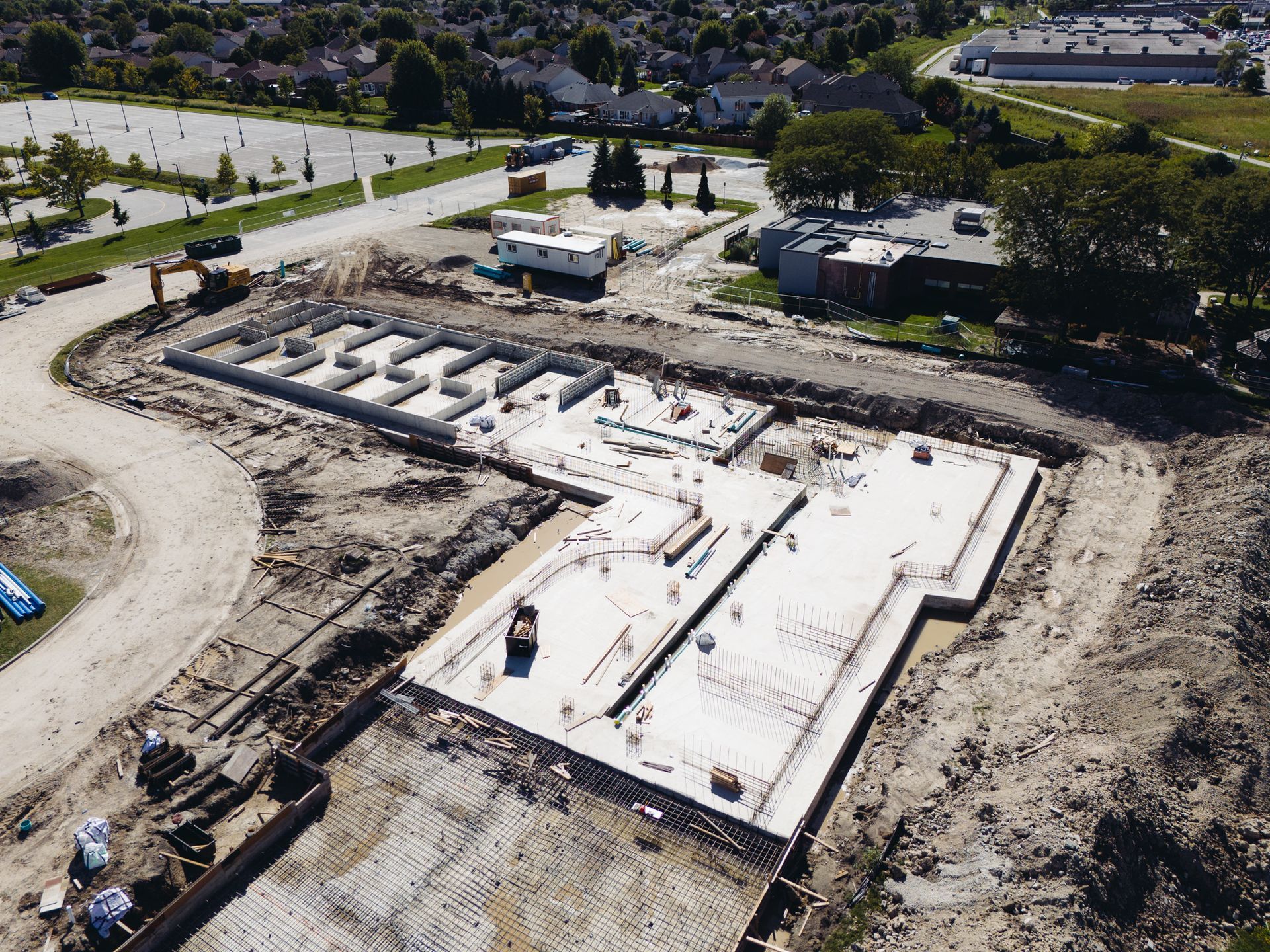 Aerial view of a construction site with a large concrete foundation and surrounding earthworks.