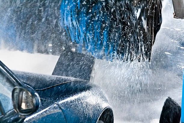 A car is being washed by a machine in a car wash.