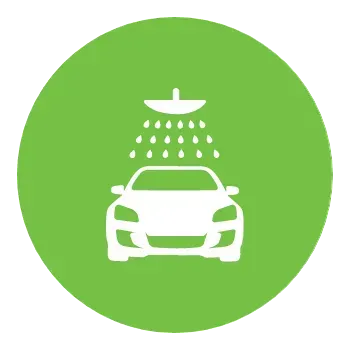 A car is being washed under a shower head in a green circle.