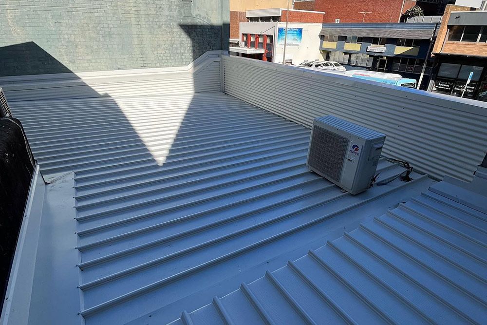 A large air conditioner is sitting on the roof of a building.