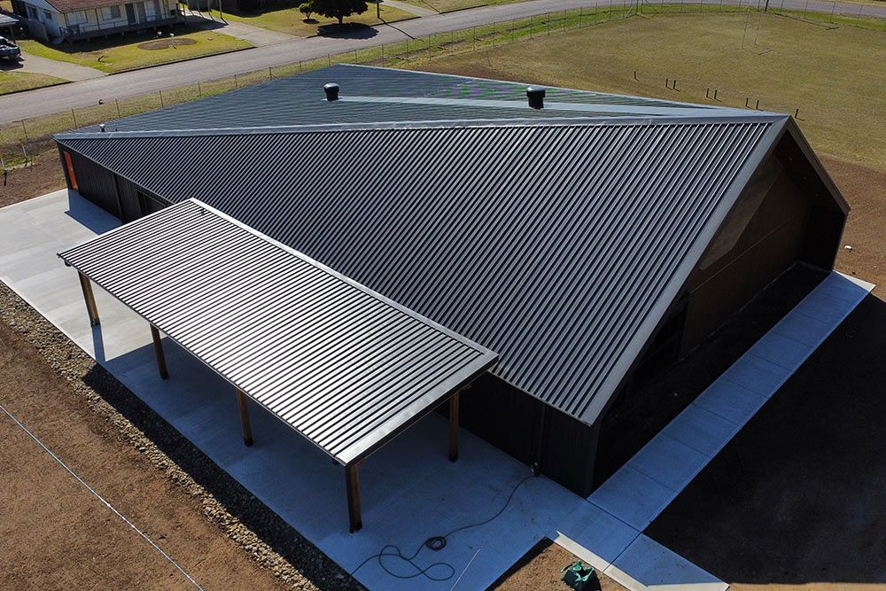 An aerial view of a building with a carport on the side.