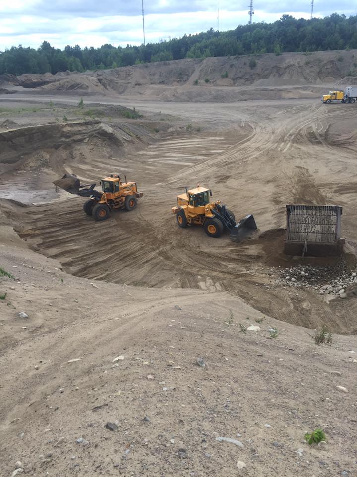 Deux bulldozers travaillent dans un champ de terre.