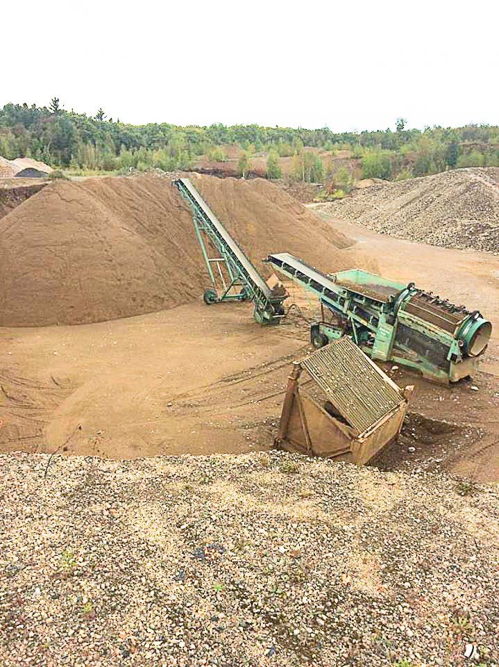 Un gros tas de terre est déplacé par un tapis roulant.