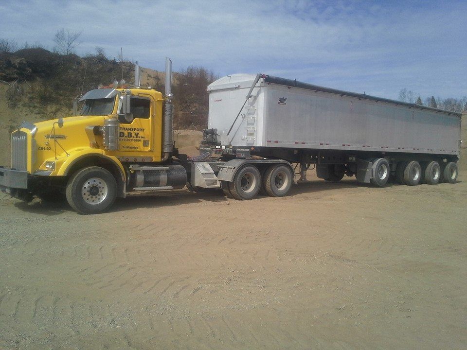 Un semi-remorque jaune avec une remorque blanche attachée