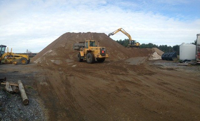 Un gros tas de terre est chargé par un bulldozer.