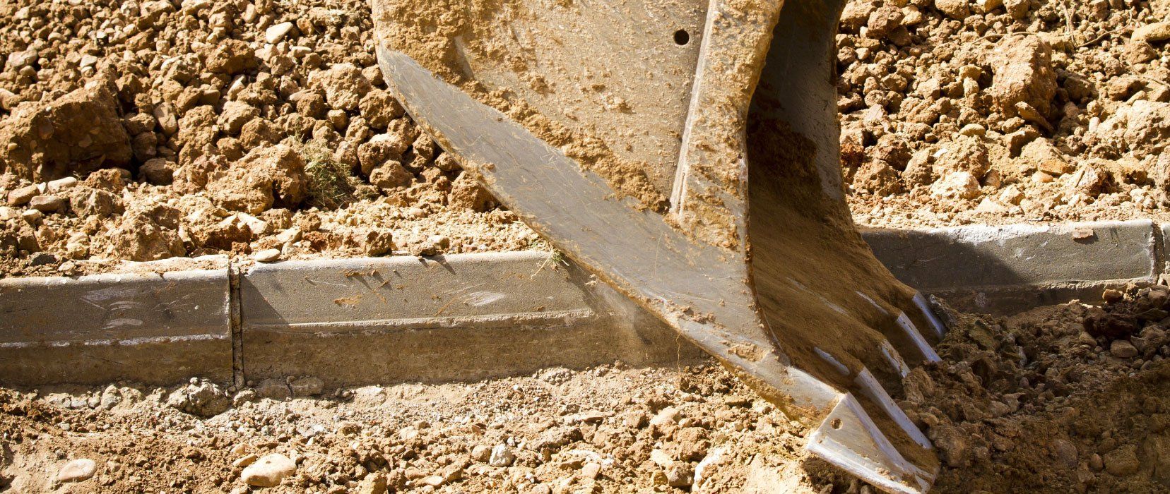 Une pelle creuse dans la terre sur un chantier de construction.