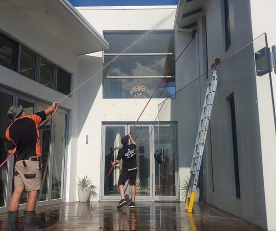 Get Wet Cleaning staff conducting soft washing method for the delicate surfaces of a house