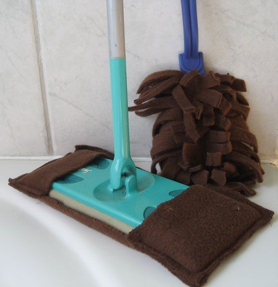 A mop with a blue handle sits next to a mop with a brown cover