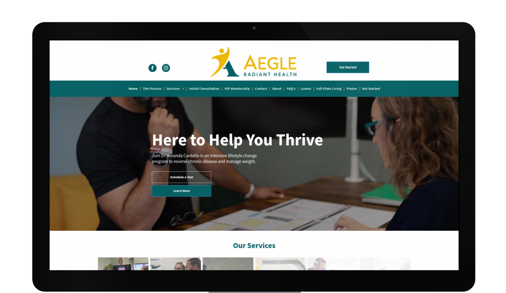 Laptop showing the Aegle Health Partners website, featuring people looking at papers, teal header and text