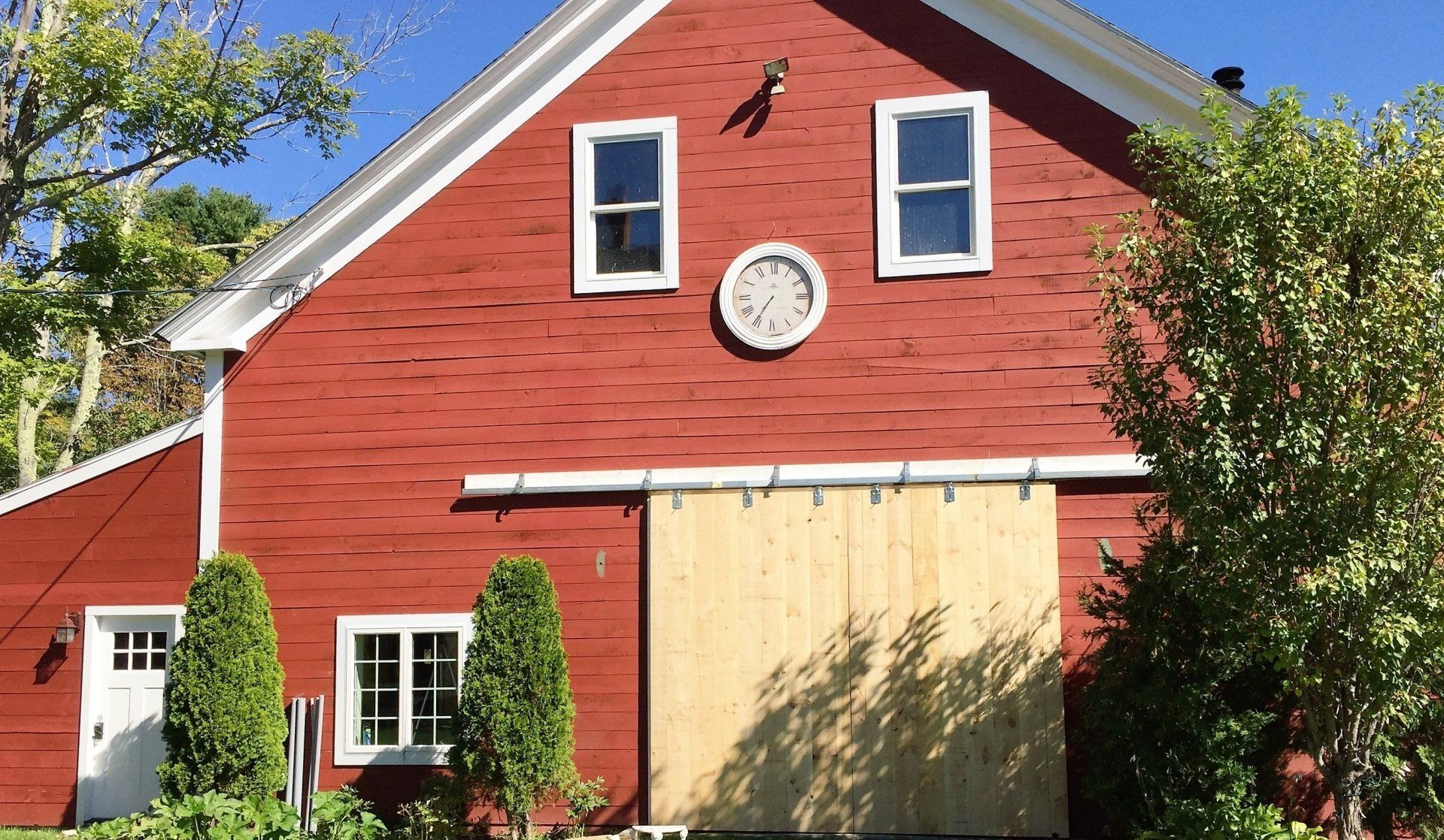 A red barn with a clock on the side of it
