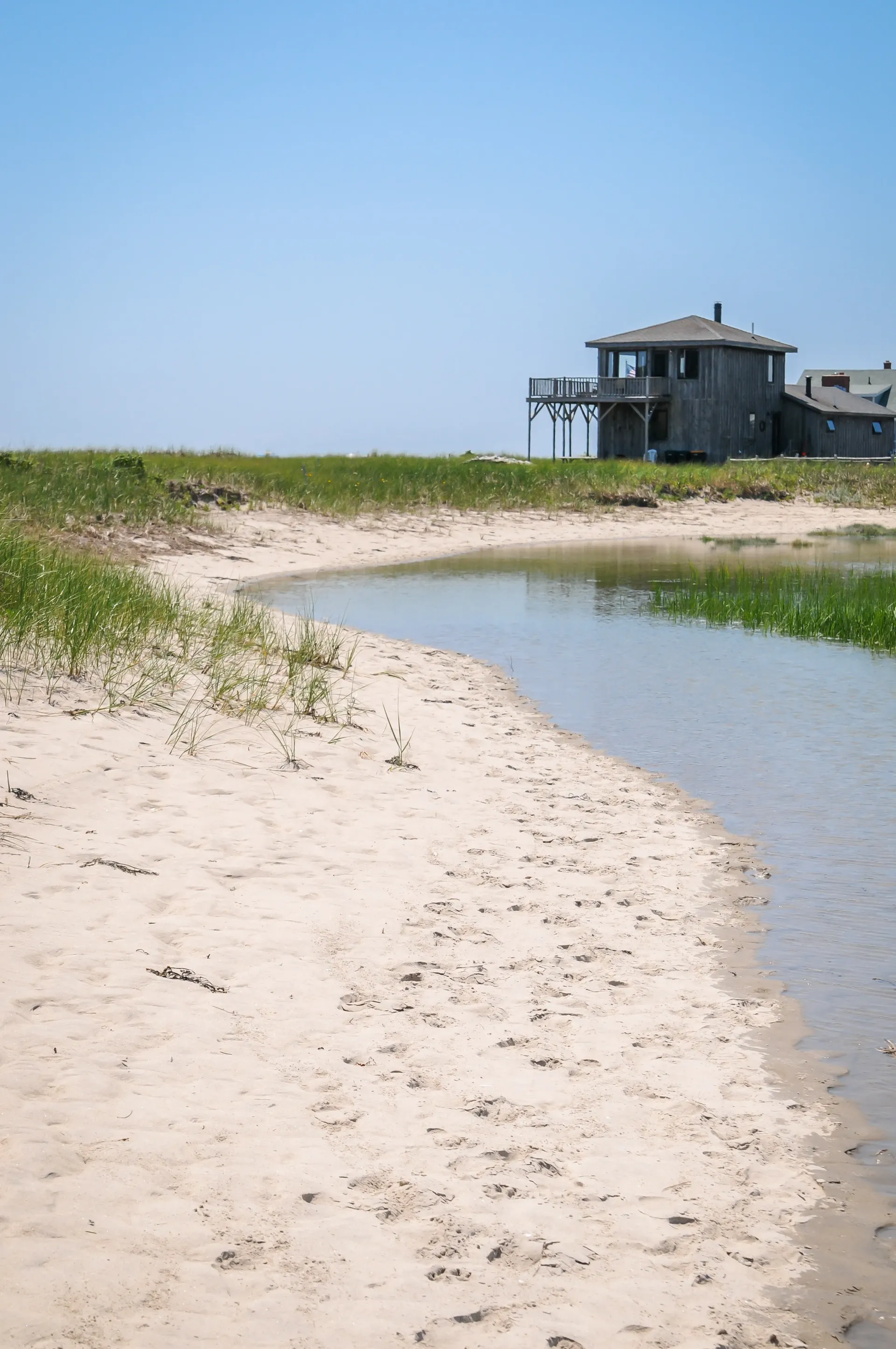A house is sitting on top of a hill next to a body of water.