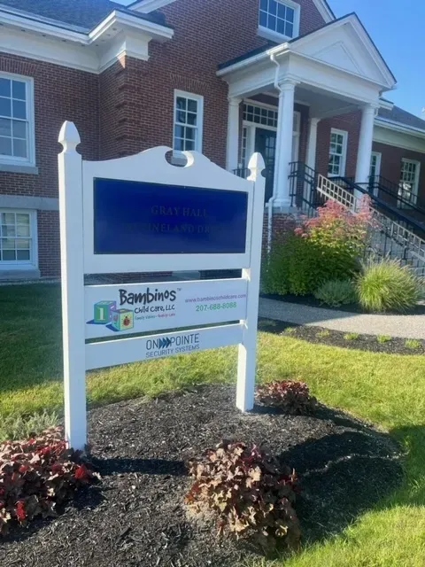 A white sign in front of a brick building that says bowbies