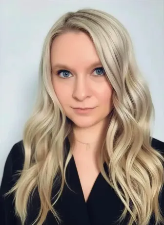 A woman with blonde hair and blue eyes is wearing a black top.