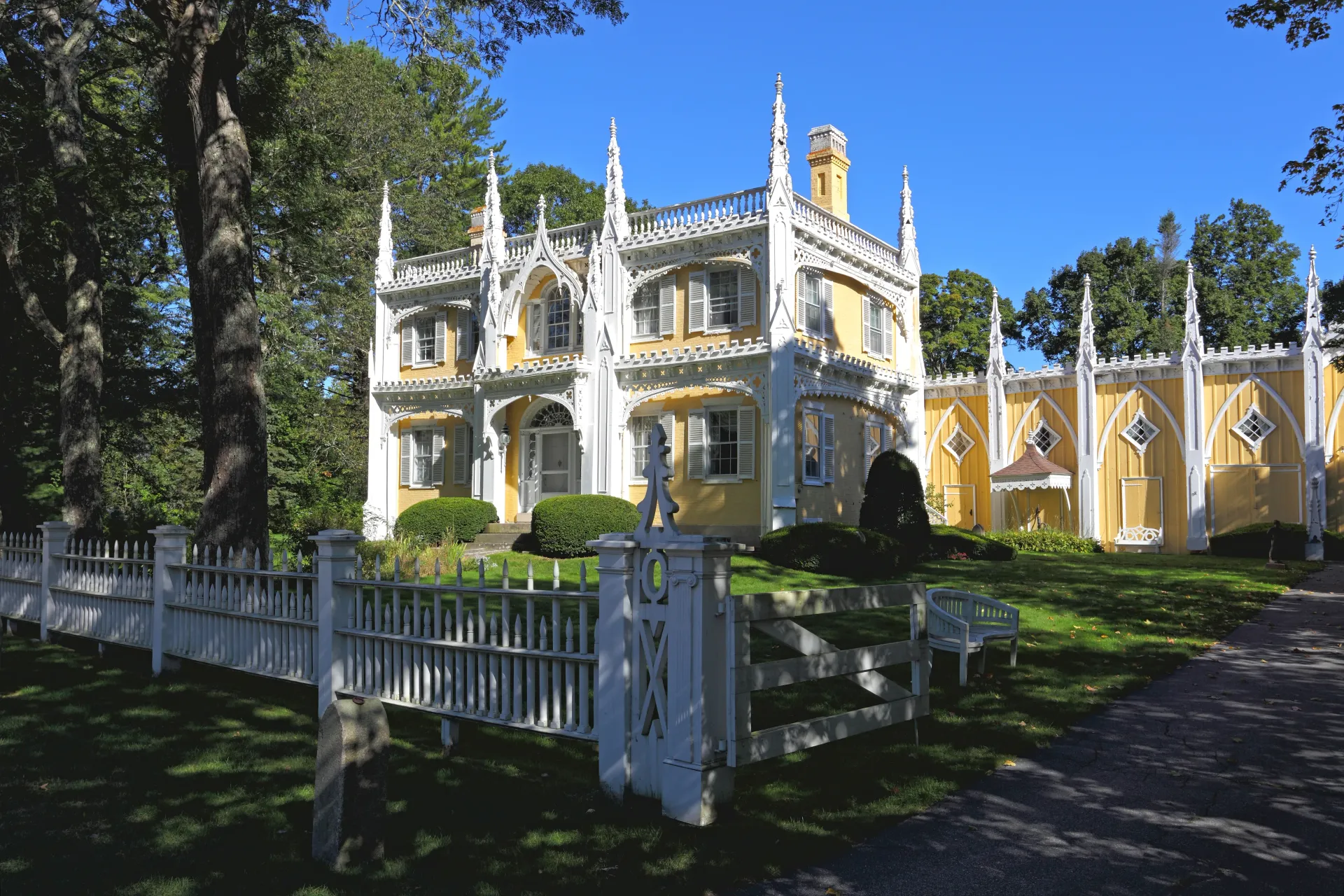 A large yellow and white house with a white picket fence
