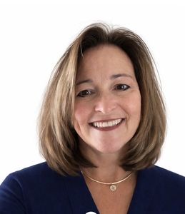 Smiling woman in a navy top against a white background