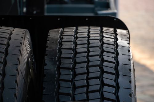 Close-up of two black truck tires with deep tread on a vehicle