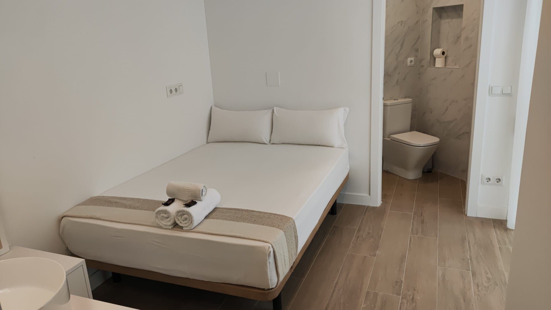 Un dormitorio con una cama, inodoro y lavabo.