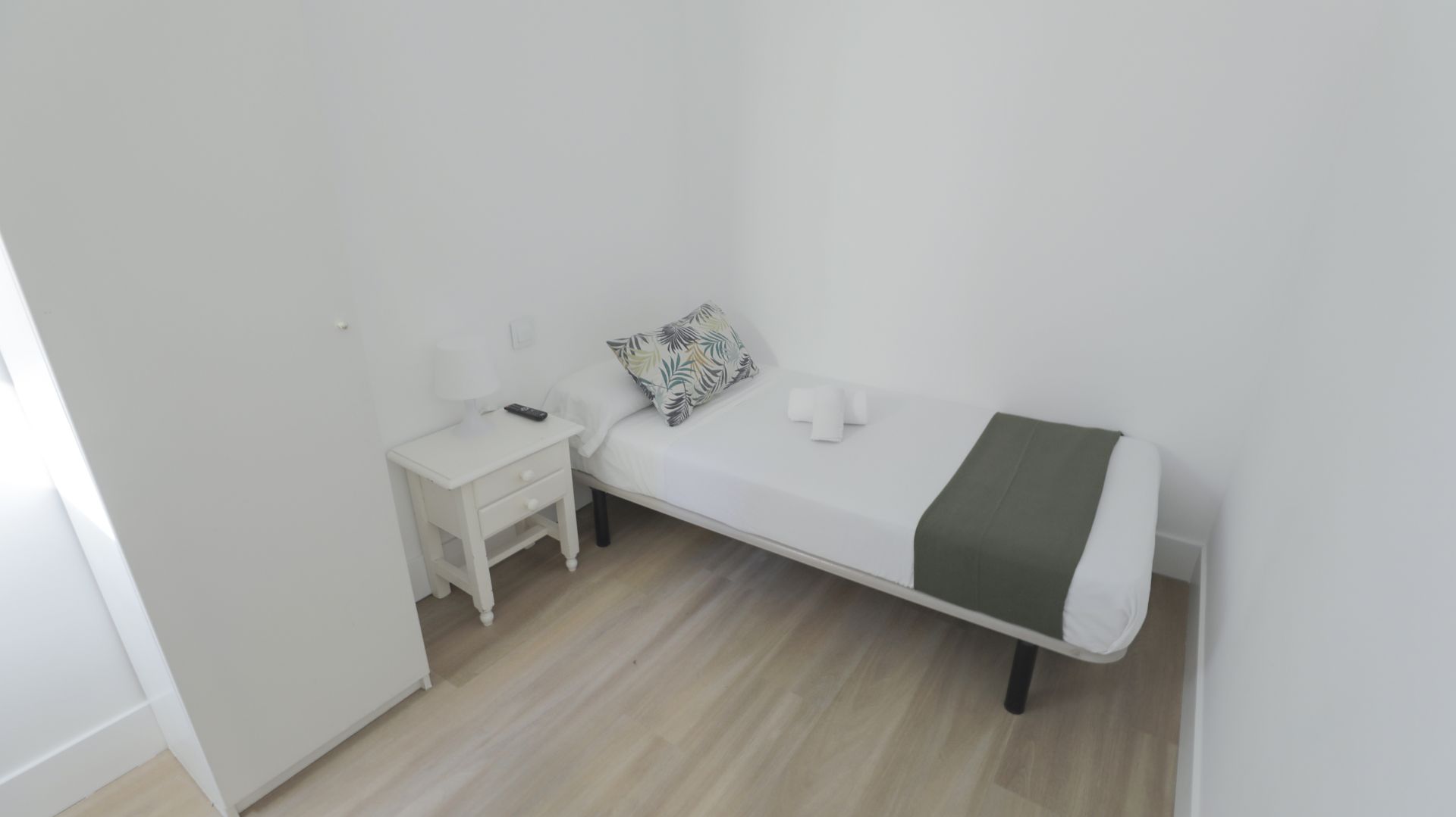 Un dormitorio con una cama individual y una mesita de noche.