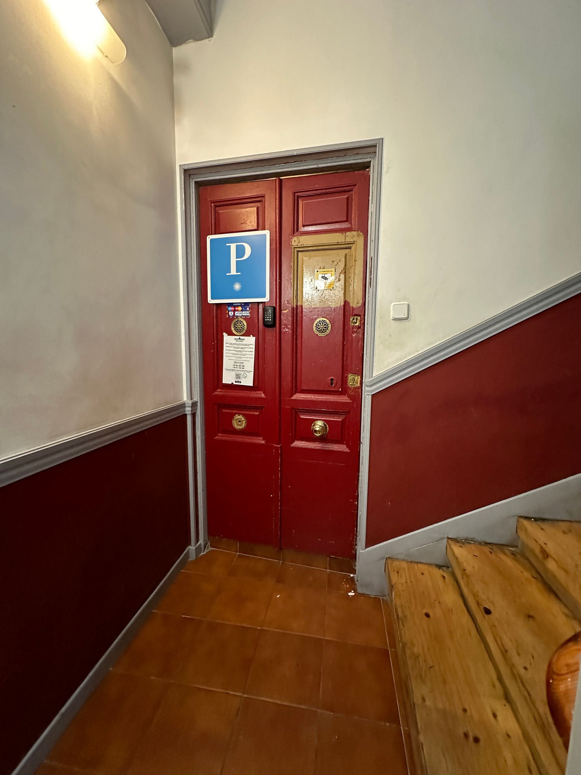 Una puerta roja con un cartel azul que dice p.