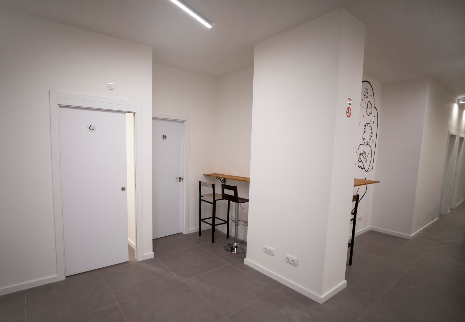 Un pasillo con una mesa y sillas en el medio.