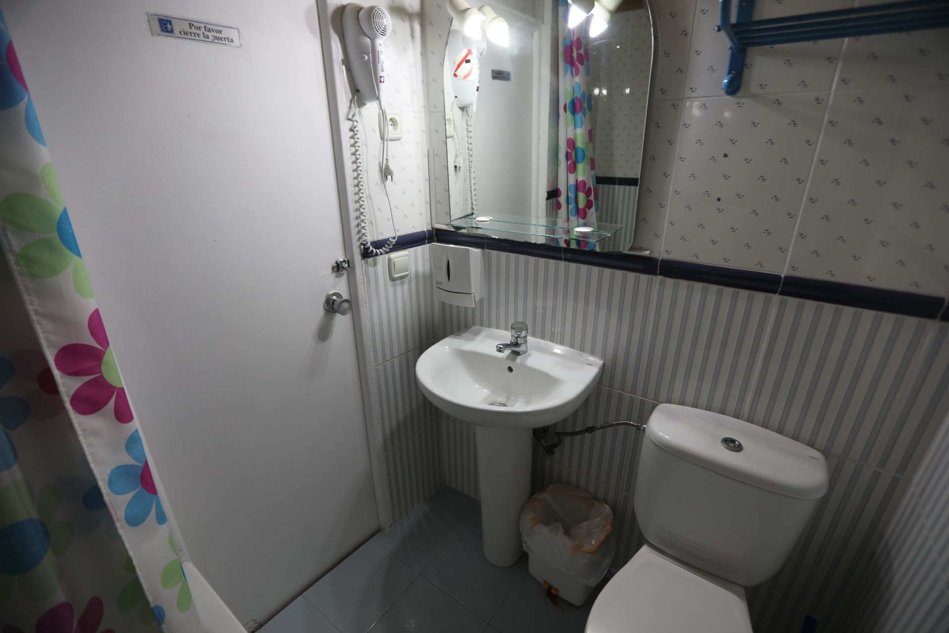 Un baño con lavabo, inodoro y cortina de ducha.