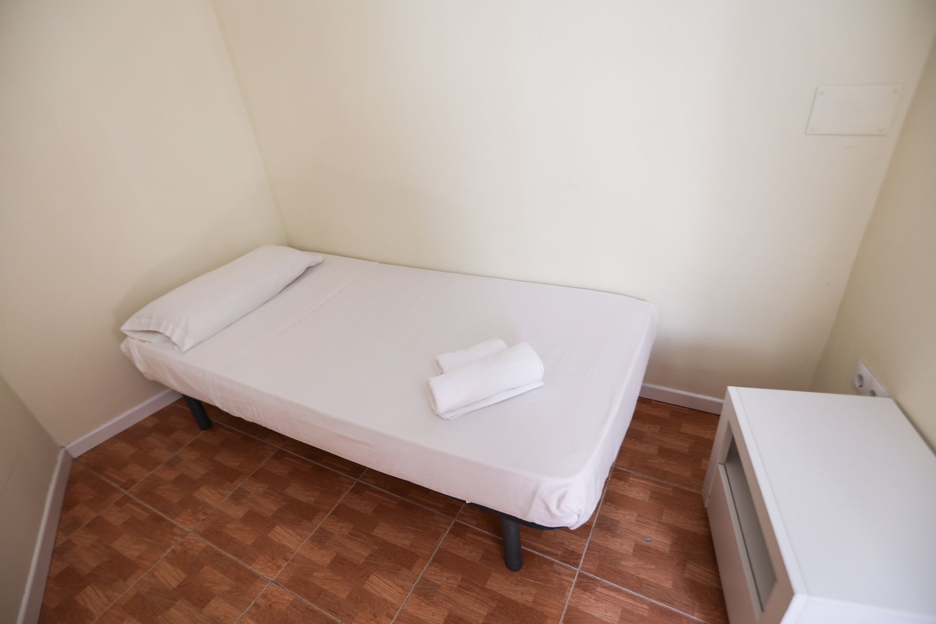 Un dormitorio pequeño con una cama individual y una mesita de noche.