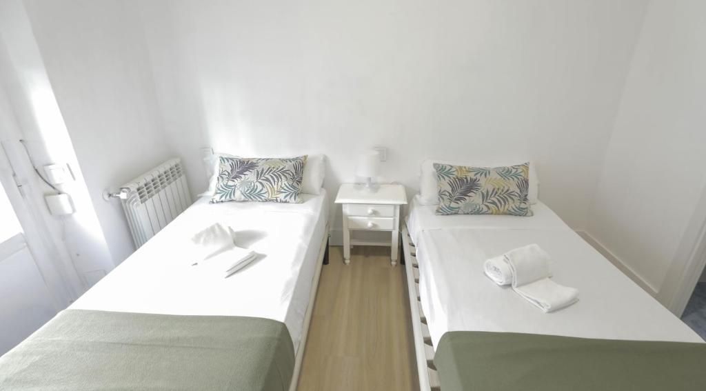 Un dormitorio con dos camas y una mesita de noche.