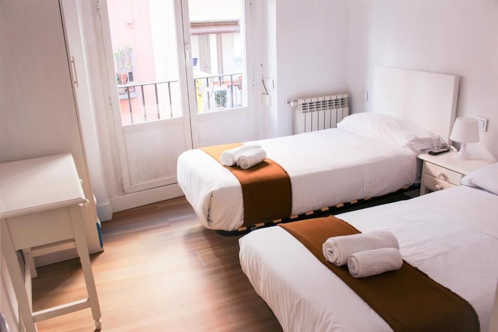 Una habitación de hotel con dos camas y una mesa.