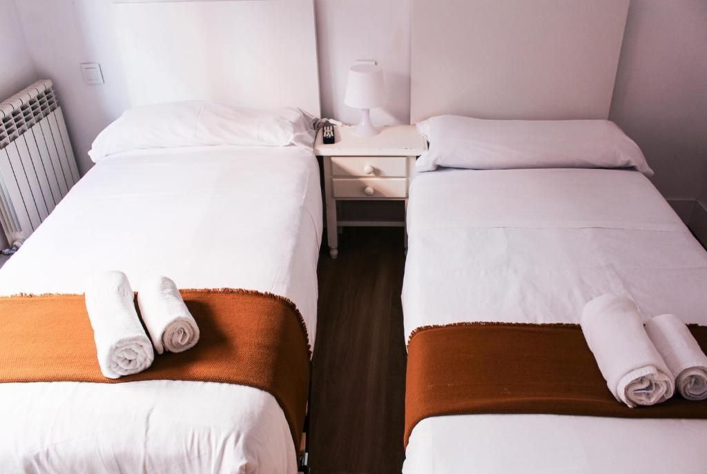 Hay dos camas en una habitación de hotel con toallas encima.