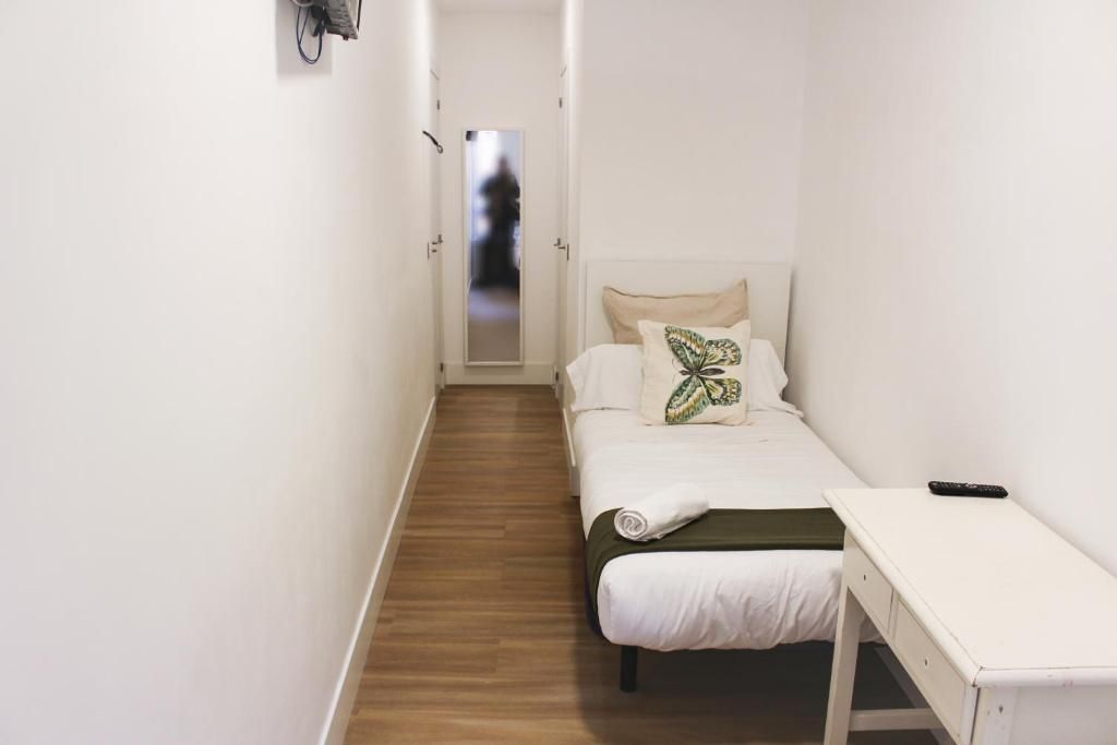 Un dormitorio con una cama individual y un escritorio.