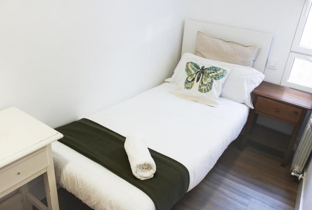 Un dormitorio con una cama individual y una almohada de mariposa.