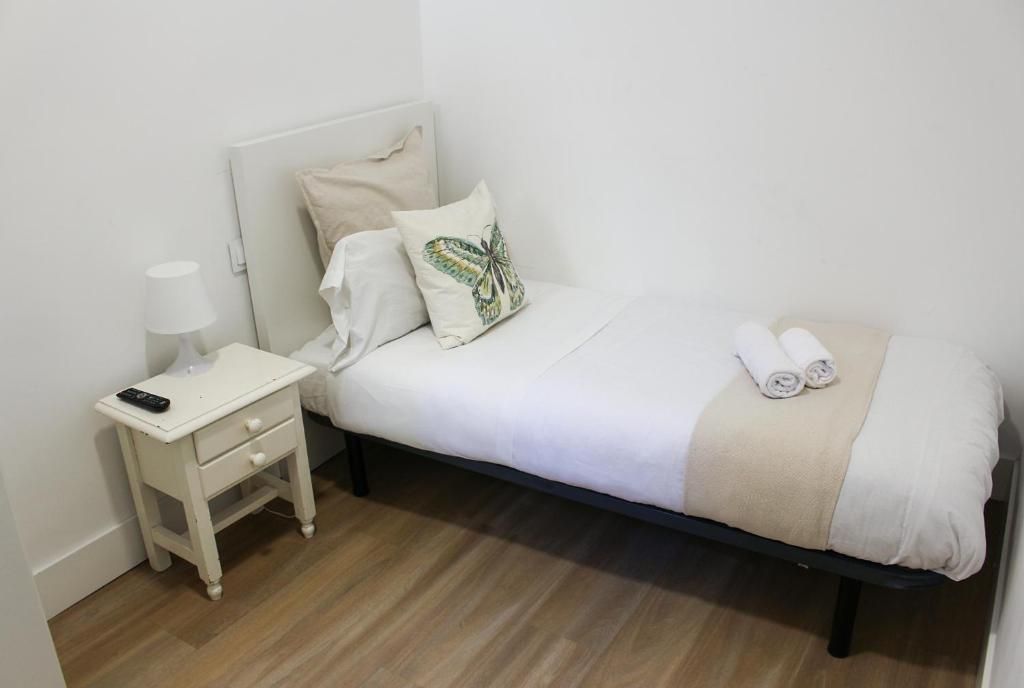 Un dormitorio con una cama individual y una mesita de noche.