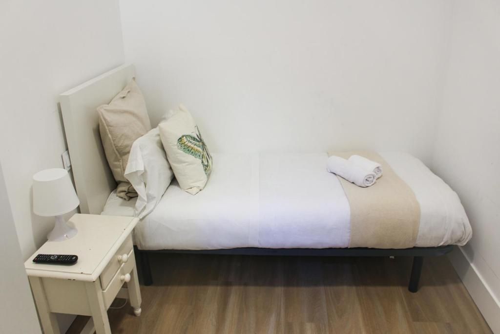 Un dormitorio con una cama individual y una mesita de noche.
