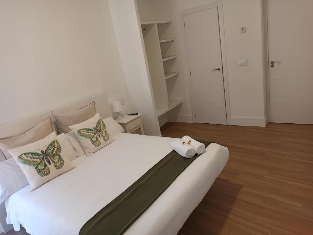 Un dormitorio con una cama king size y almohadas de mariposa.