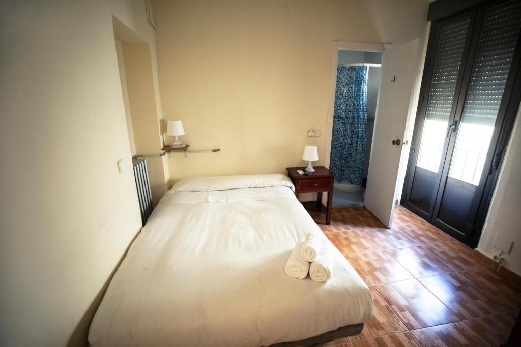 Un dormitorio con una cama, mesita de noche y armario.