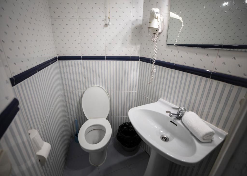 Un baño con inodoro, lavabo y espejo.