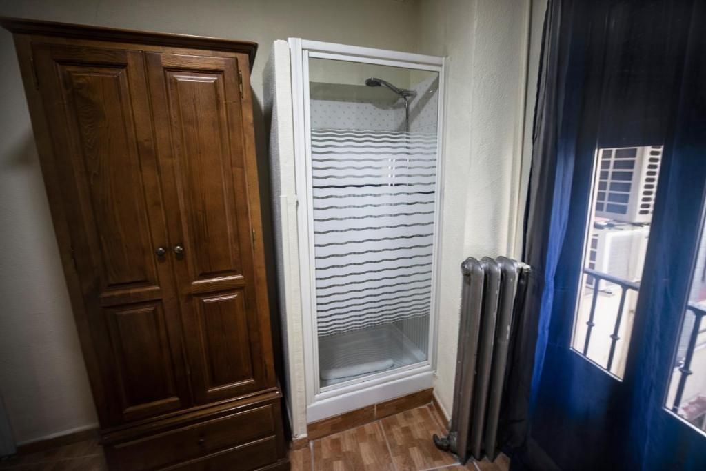 Un baño con ducha a ras de suelo y un mueble de madera.