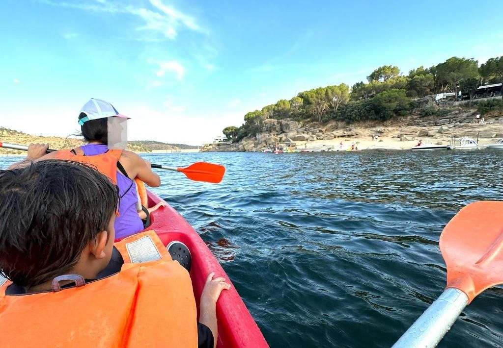 Un grupo de personas están remando en kayaks en un lago.