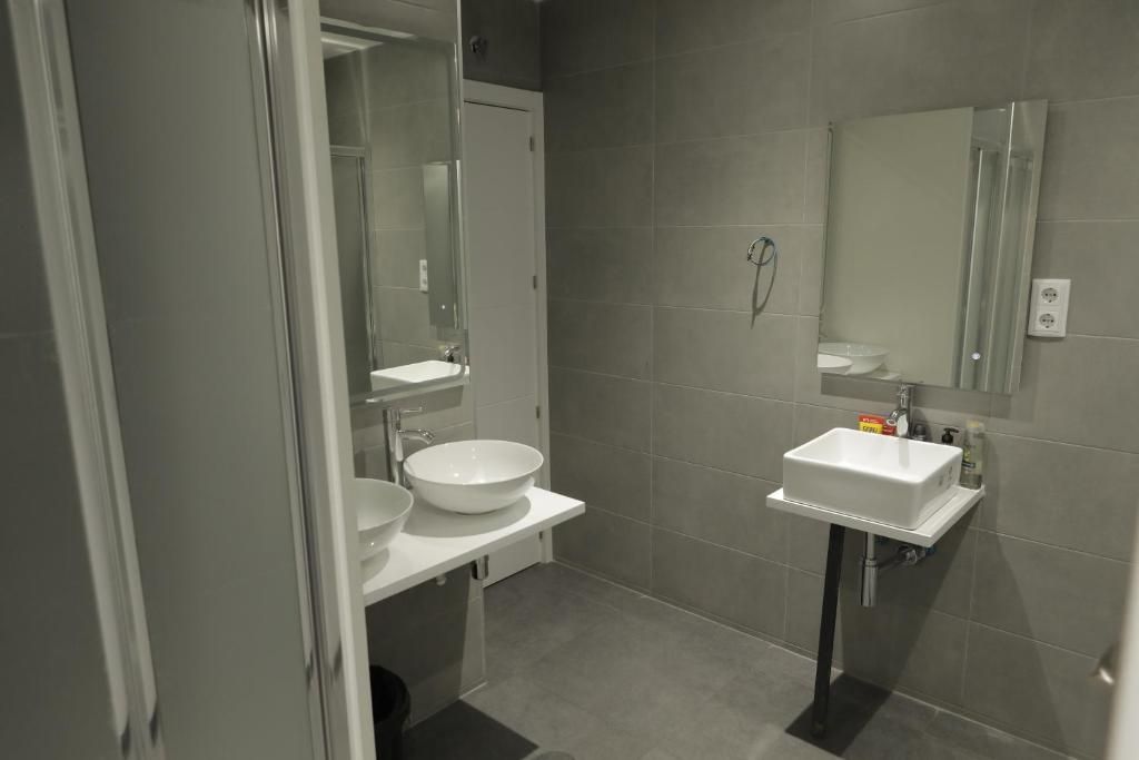 Un baño con dos lavabos, un espejo y una ducha.