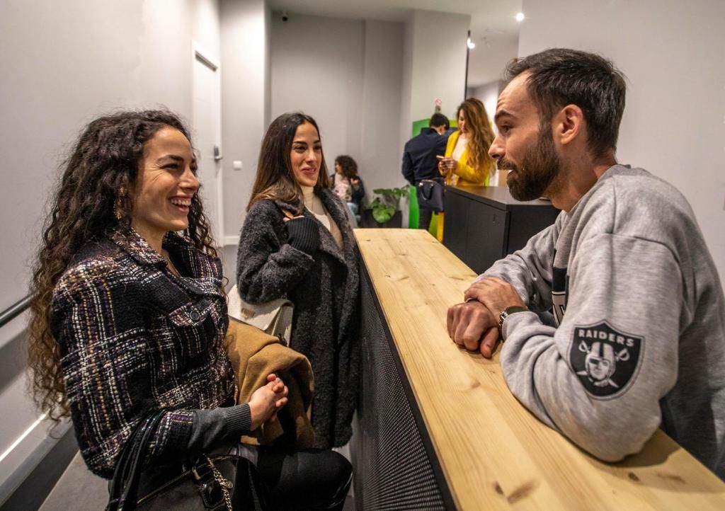 Un hombre y dos mujeres están sentados en un mostrador hablando entre sí.