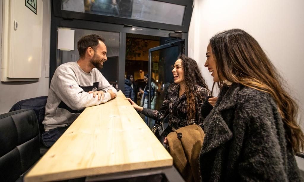 Un hombre y dos mujeres están sentados en una mesa en un restaurante.