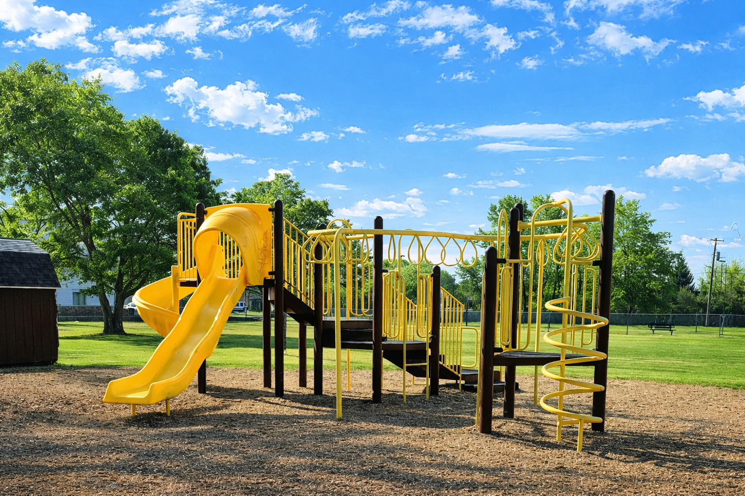 A wooden console table under a blank picture frame, with a tripod floor lamp and potted plants in a bright, modern room.