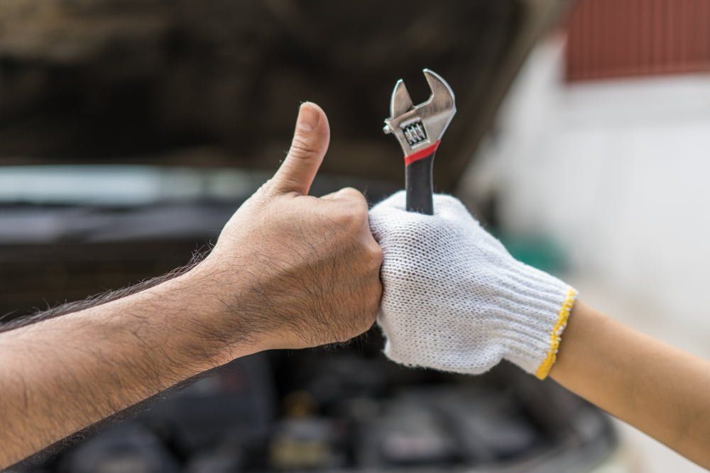 A Man and a Woman Are Giving Each Other a Thumbs Up  — BJM Mechanical Mufflers & Tyres In Oxenford, QLD