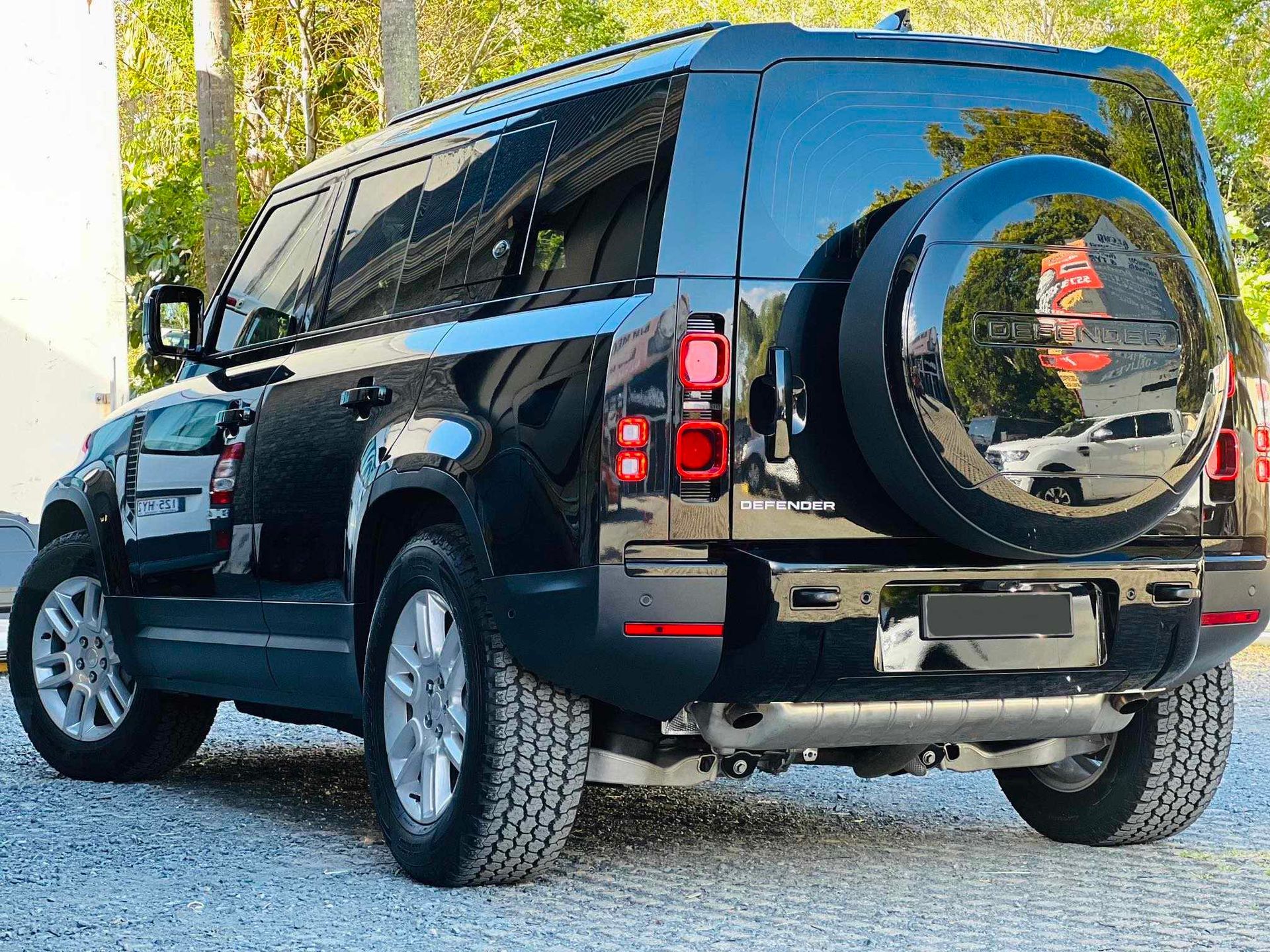 A Black Land Rover Defender is Parked in a Gravel Lot — BJM Mechanical Mufflers & Tyres In Oxenford, QLD