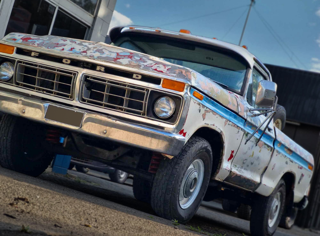 A White Truck is Parked on the Side of the Road in Front of a Building — BJM Mechanical Mufflers & Tyres In Oxenford, QLD