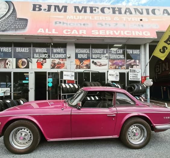 A Pink Car is Parked in Front of Bjm Mechanica — BJM Mechanical Mufflers & Tyres In Oxenford, QLD