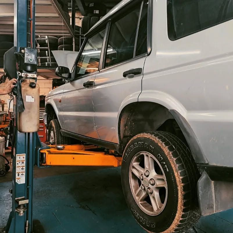 Silver SUV On An Orange Car Lift In A Garage — BJM Mechanical Mufflers & Tyres On The Gold Coast, QLD