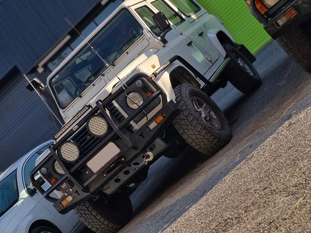 White Land Rover Defender Parked On A Paved Lot — BJM Mechanical Mufflers & Tyres On The Gold Coast, QLD
