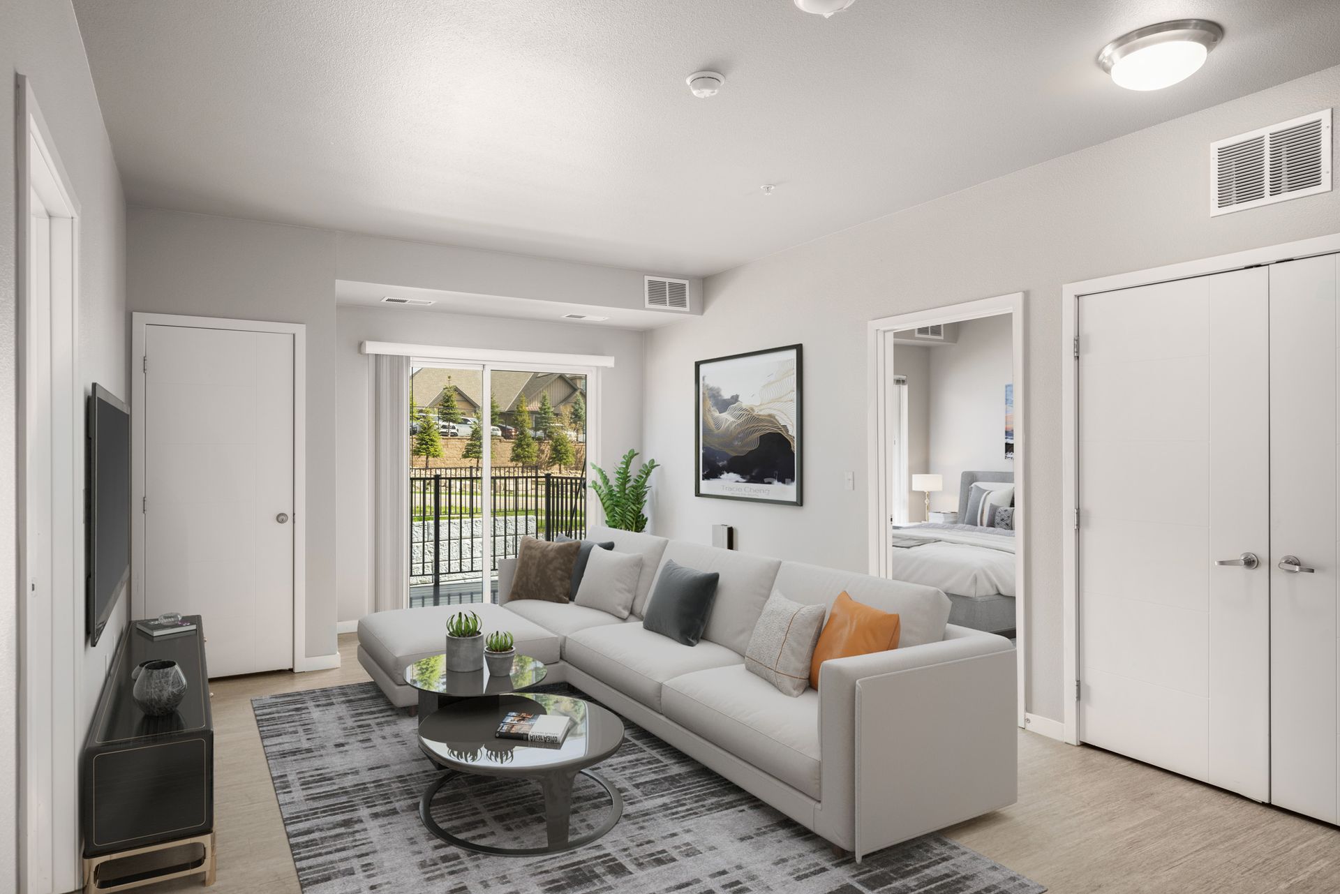 Living room with white sofa, coffee table, and balcony access.