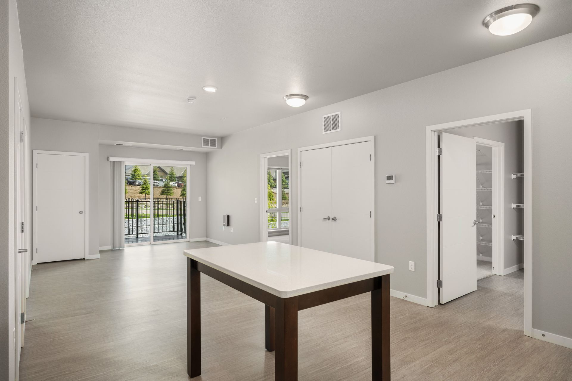 Bright interior with an island, doors, and a balcony overlooking a scenic view.